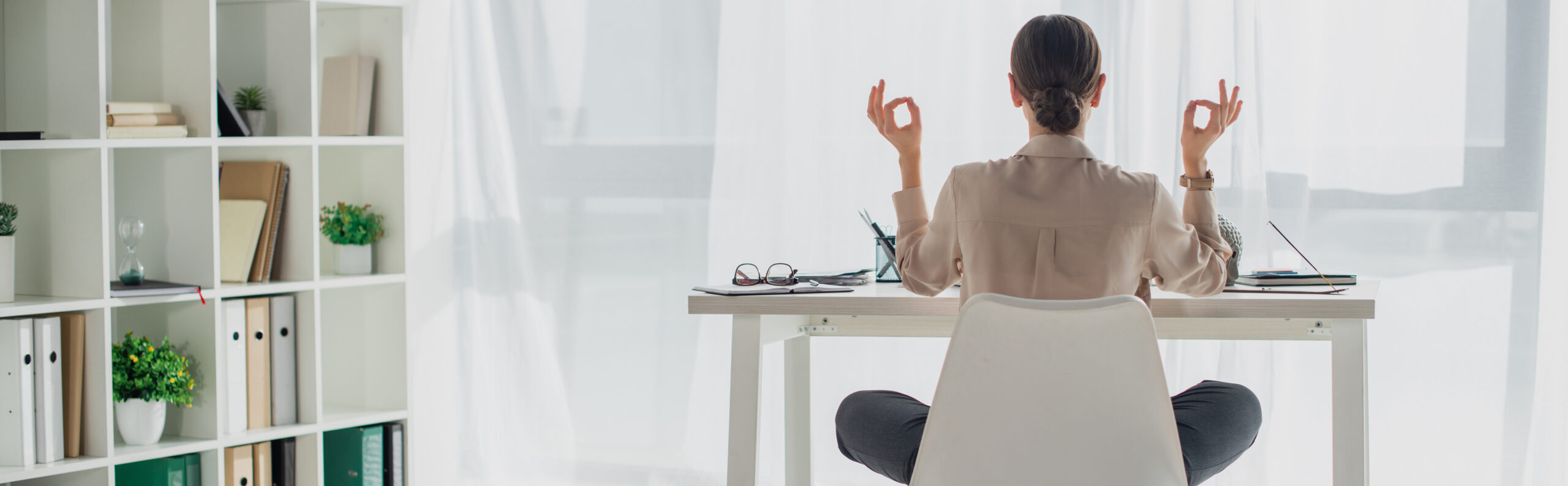 panoramic shot of businesswoman meditating in lotus pose with gy